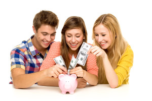 Young people putting money in piggy bank